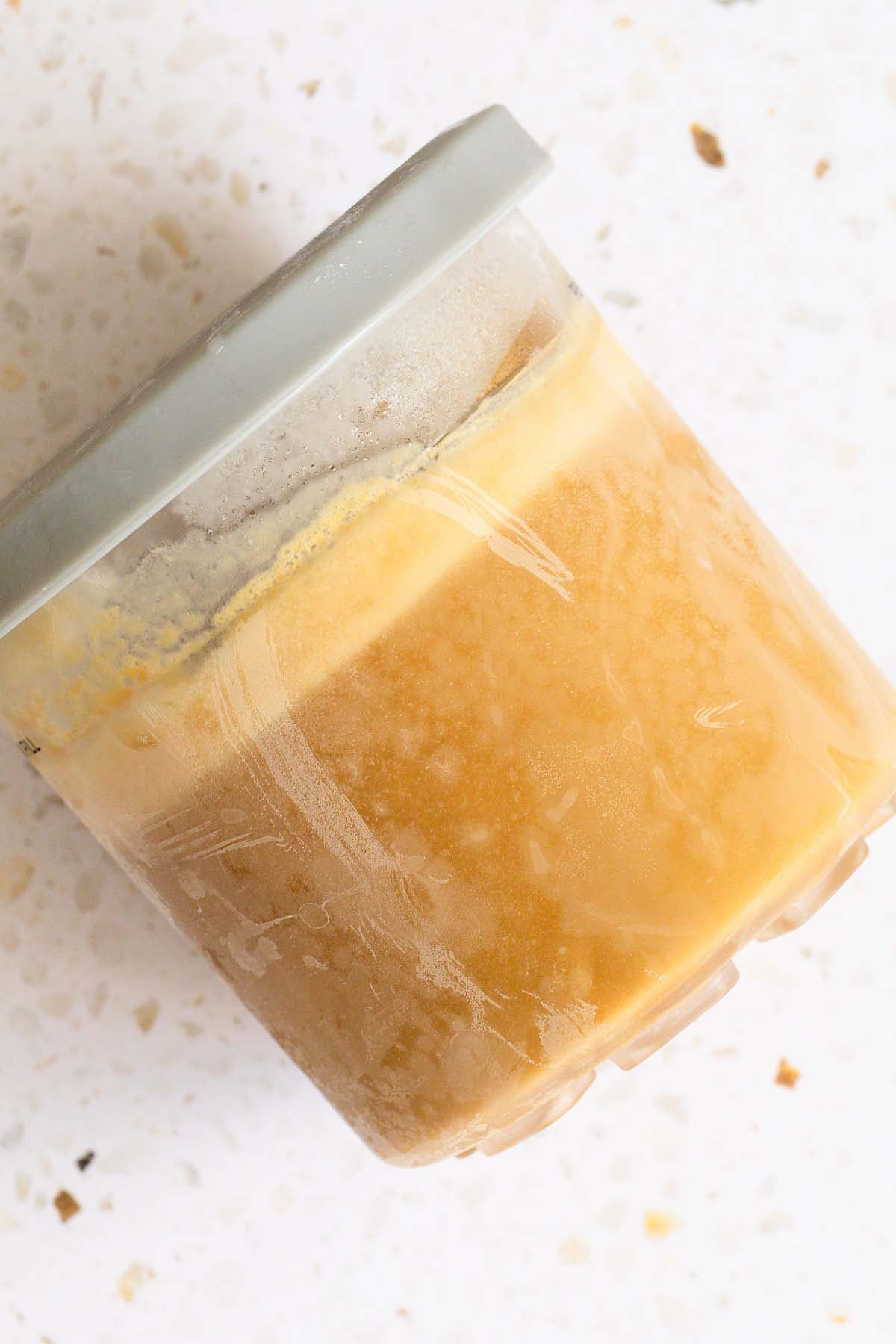 Frozen Ninja Creami salted caramel ice cream in Ninja Creami container